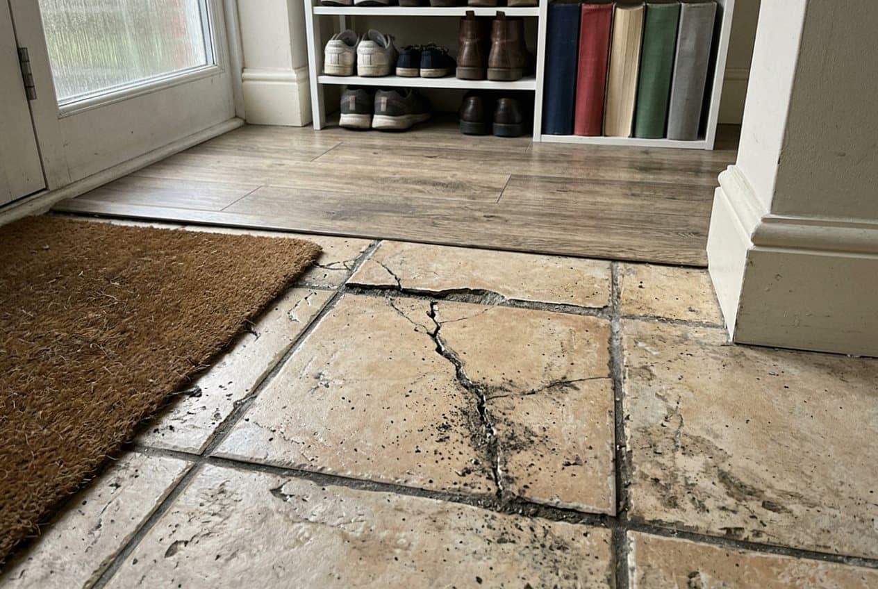 Cracked stone entry tile before repair