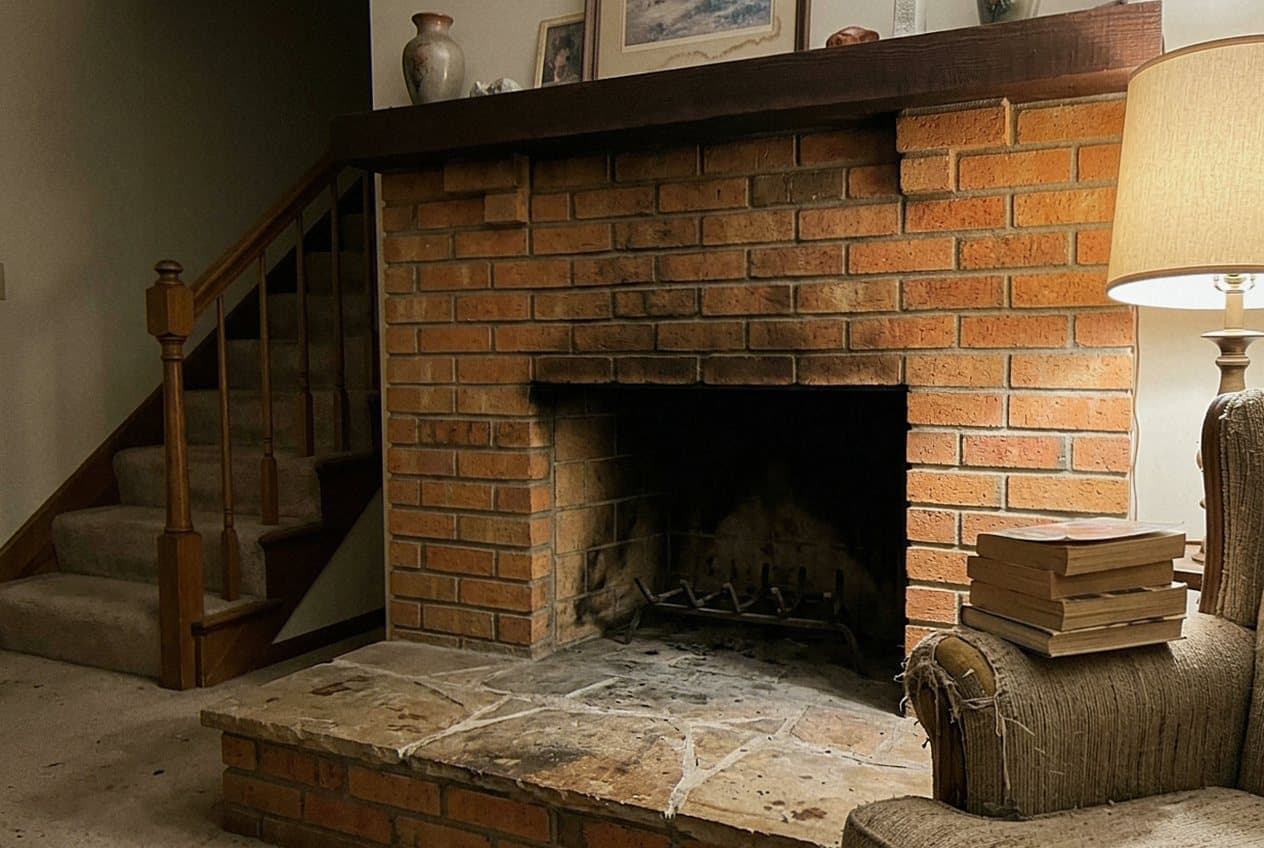 Dated brick fireplace with a worn stone hearth
